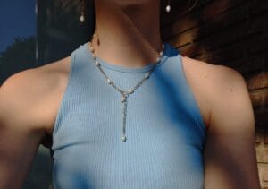 ketting met kralen en goud op een blauw topje