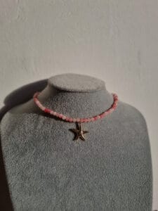 roze kralenketting met een gouden zeester
