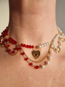 ketting met goud, witte en rode kralen en een gouden hartje