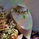 ketting met groene blaadjes, roze vlinders en goud