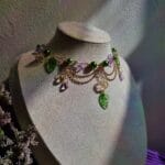 ketting met groene blaadjes, roze vlinders en goud