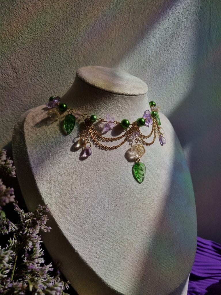 ketting met groene blaadjes, roze vlinders en goud