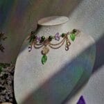 ketting met groene blaadjes, roze vlinders en goud