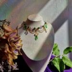 ketting met groene blaadjes, roze vlinders en goud