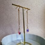 gouden oorbellen met doorzichtige regenboogachtige kralen