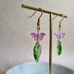 oorbellen met groene blaadjes en roze vlinder