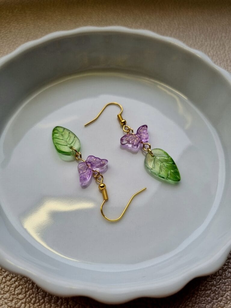oorbellen met groene blaadjes en roze vlinder