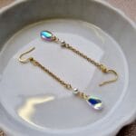 gouden oorbellen met doorzichtige regenboogachtige kralen