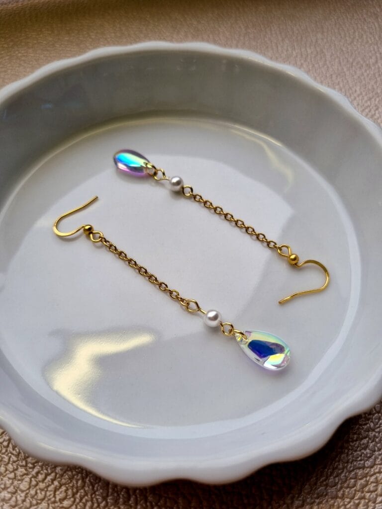 gouden oorbellen met doorzichtige regenboogachtige kralen